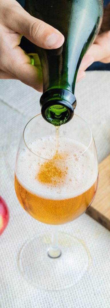 A bottle pouring cider into a glass